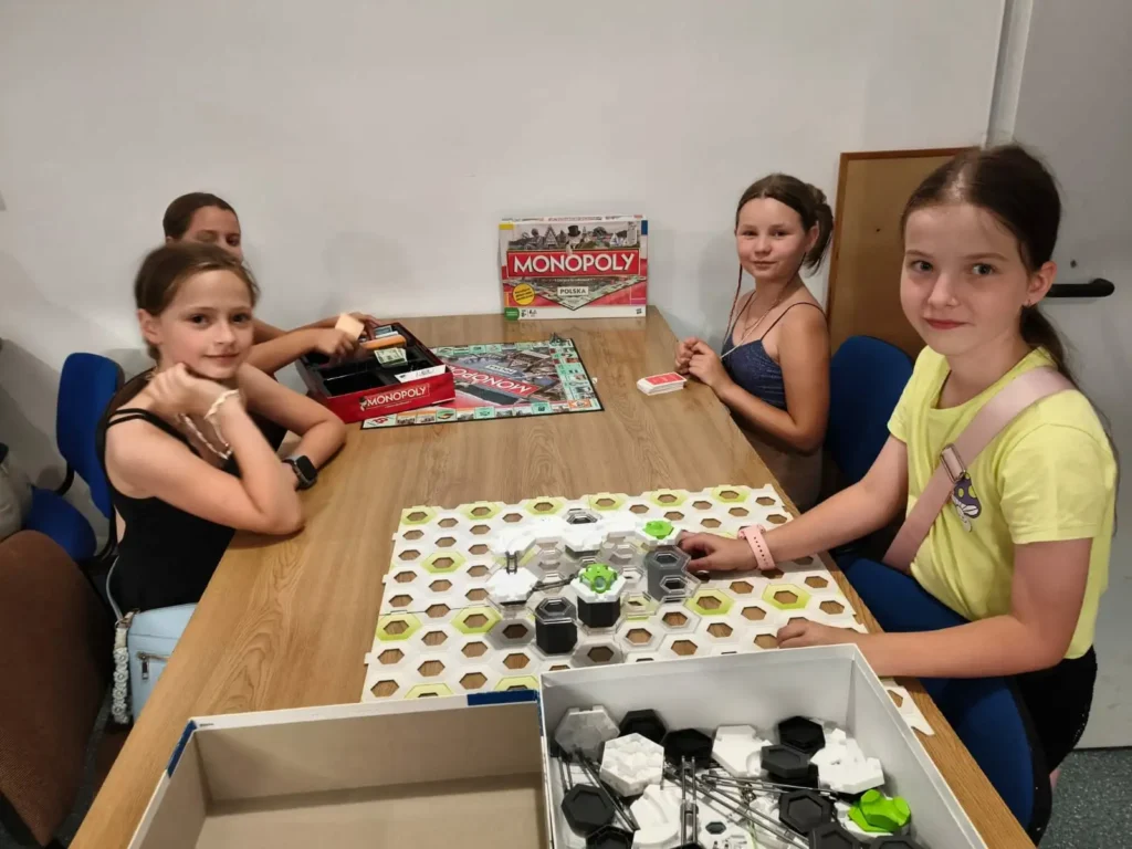 Dzieci grają w gry planszowe podczas spotkania Dąbrowskiego Klubu Gier